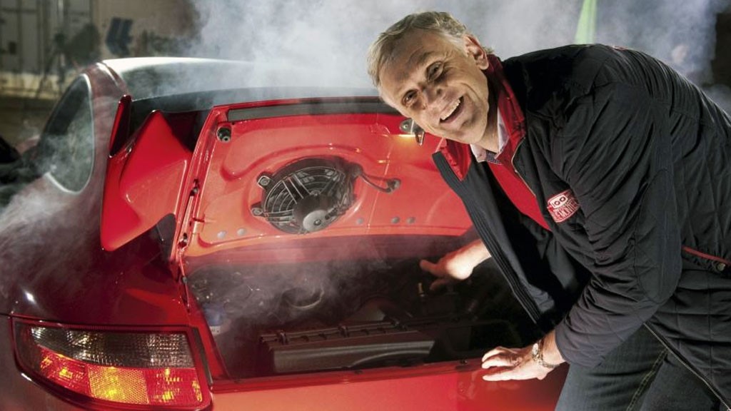Bilteknisk konsulent i NAF, Benny Christensen smiler bak en rød bil